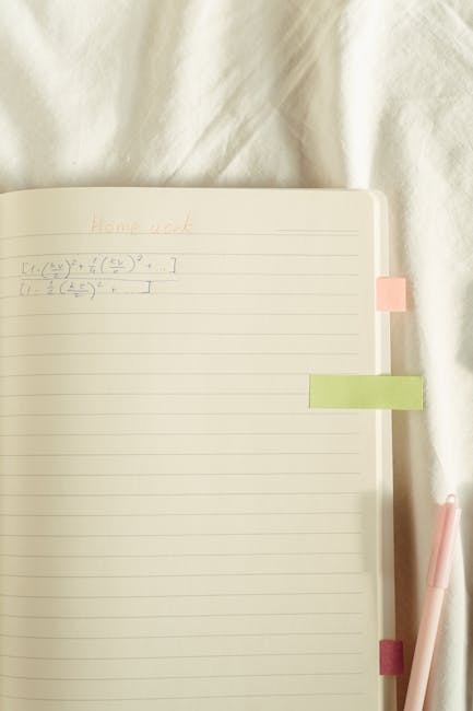 Open notebook with math equations, pastel sticky notes, and a pen on a soft surface.